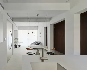 A modern residential kitchen featuring a concrete countertop and minimalist design elements.
