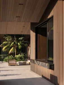 Modern residential patio featuring a wooden ceiling, marble countertop, and metal railings.