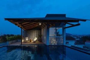 Modern rooftop terrace with glass pool and wooden deck.