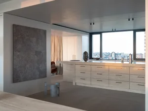 Modern residential kitchen featuring a white marble countertop and island with spacious seating area.