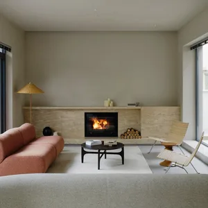 Modern minimalist living room with a concrete fireplace, orange sofa, and white chairs.