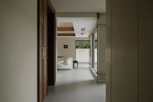 A minimalist living room featuring concrete walls and floor.