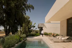 A minimalist residential exterior featuring concrete and glass materials.