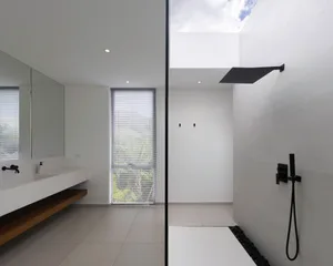 Modern bathroom with concrete walls and floor, minimalist design, and skylight