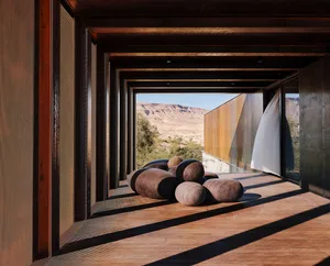 Modern interior design featuring dark finishes and a desert view.
