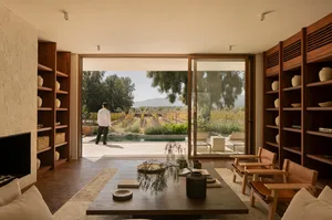 Modern living room featuring wooden furniture, glass walls, and stone accents.