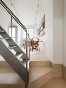 A modern living room with a concrete floor, minimalist furniture, and a large window