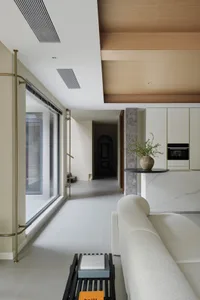 Modern living room with concrete floor and marble accents featuring a white sofa and black coffee table.