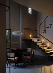 A modern living room with wooden stairs and metal railing.