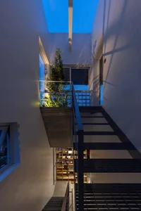 Modern concrete and metal living space with skylight and indoor plants