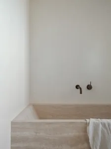 Minimalist, modern bathroom with marble and concrete finishes.