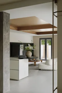 Modern minimalist living room with white furniture, wooden ceiling beams, and a potted plant on a low table.