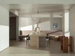 A modern minimalist living room with a neutral color palette featuring minimal furniture and design.