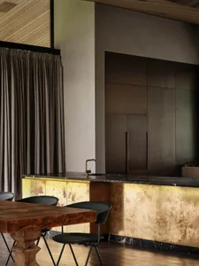 Modern industrial kitchen featuring brass accents and marble countertops.