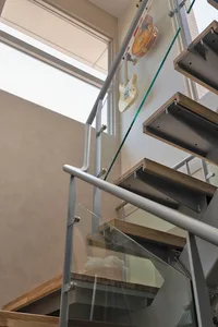 Modern industrial floating stairs with wood tread and steel railing.