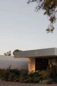 A minimalist house with concrete exterior and glass accents.