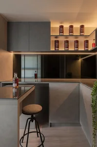 Modern, minimalist residential kitchen featuring concrete countertops and cabinets with ambient lighting.