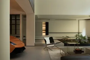 A modern living room featuring concrete and glass elements.