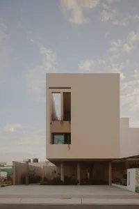 A minimalist modern house featuring a concrete exterior and large windows.