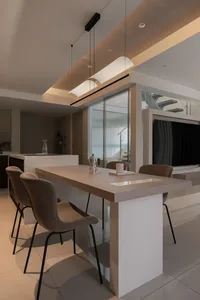Modern minimalist dining room with a wooden table, chairs, and minimalistic lighting.