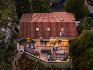 Aerial view of a residential home with a red terracotta roof and outdoor patio area.