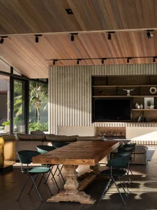 Modern industrial living room with wooden furniture and corrugated metal accent wall.