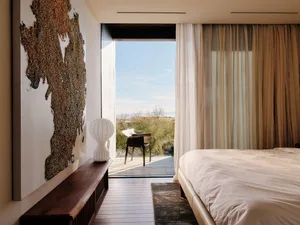 Minimalist bedroom with neutral tones and a view of nature.