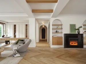 A modern, minimalist living room with wooden floors and furniture.
