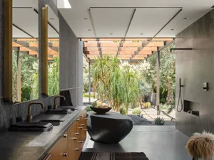 Modern bathroom featuring concrete countertops, wooden accents, and metal fixtures.