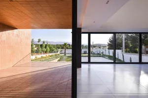 A modern interior space featuring glass walls and extensive windows.
