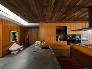 Modern kitchen featuring wooden countertops and cabinets, with a marble backsplash and stainless steel appliances.