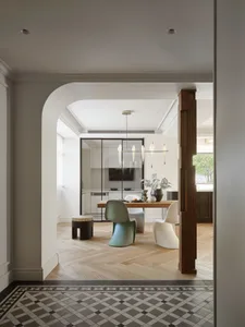 Modern minimalist residential kitchen with wooden table, glass pendant lights, and minimalist furniture.