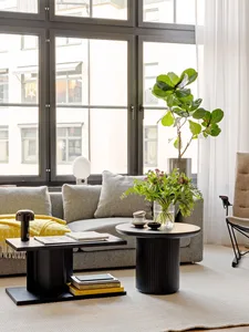 A modern living room with neutral tones and a large window.