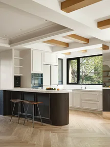 Modern residential kitchen featuring white marble countertops and wooden accents