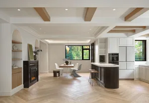 A modern kitchen featuring a white kitchen counter with a wood and marble texture, stainless steel appliances, and a white ar