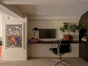 An industrial-style workspace featuring black office furniture, a white backdrop, and minimalist decor.