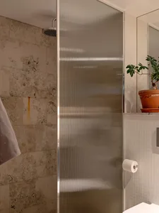 A minimalist bathroom featuring a glass shower enclosure.