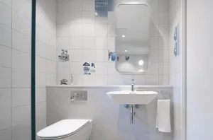 Modern minimalist bathroom with white tiles and fixtures.