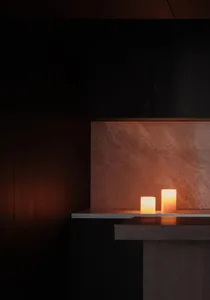 Candles illuminated on a minimalist interior shelf
