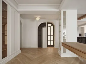 A minimalist residential interior with white walls, arched doorways, and wooden accents.