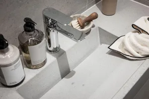 Modern bathroom interior featuring a sleek concrete countertop and minimalist fixtures.