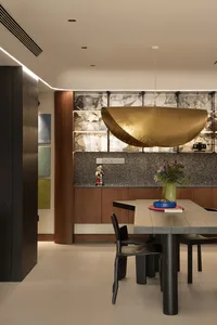 Modern dining room with dark wood furniture and marble countertops.