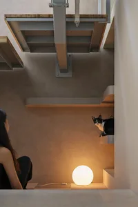 A modern, industrial-style staircase with concrete steps and a white sphere light on the floor.