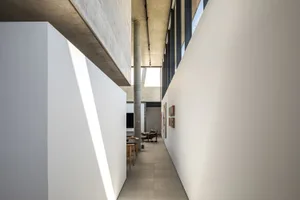 Modern architectural space with minimalist design, concrete walls, and large windows.