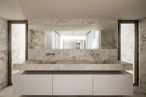 Modern bathroom featuring marble countertops and walls
