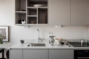 Modern minimalist kitchen with concrete countertop and stainless steel sink.