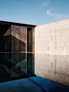 Modern minimalist concrete swimming pool reflecting the surrounding environment.
