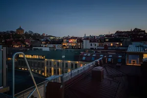 城市夜景屋頂景觀，燈火通明的建築與晴朗天空。