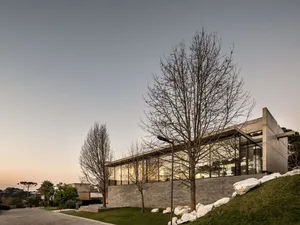 A minimalist house with a concrete exterior and large windows.