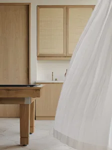 A minimalist residential bedroom featuring light wood elements.